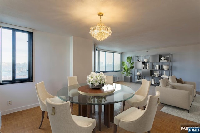 dining space featuring a chandelier and baseboards