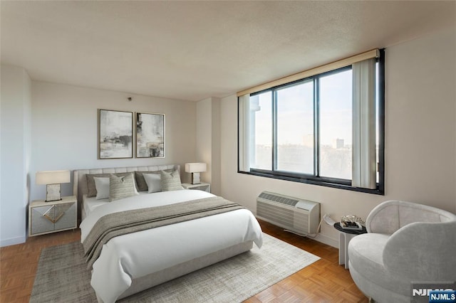 bedroom with baseboards and a wall mounted air conditioner