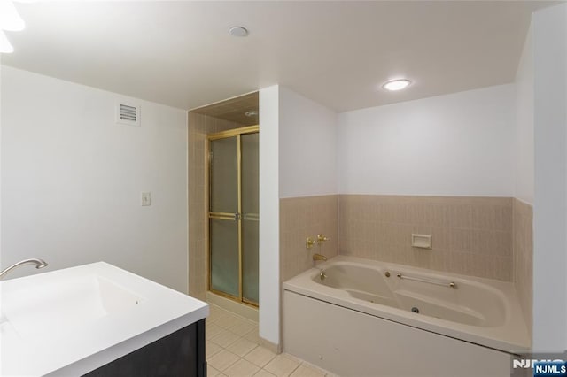 bathroom featuring tile patterned flooring, a shower stall, a whirlpool tub, and a sink