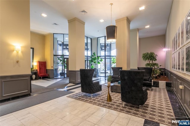 common area featuring a decorative wall, crown molding, and recessed lighting