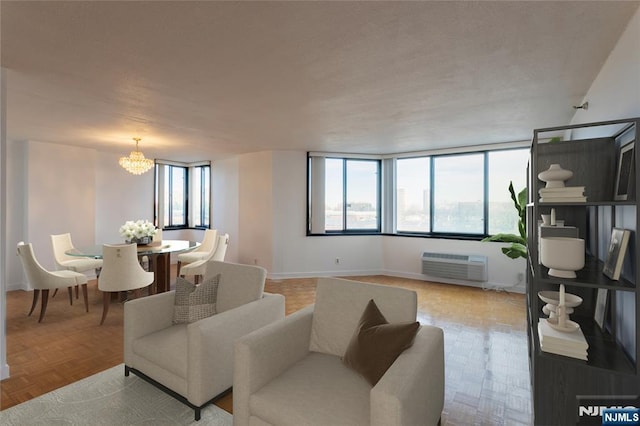 living room featuring a wall mounted AC, a chandelier, and baseboards