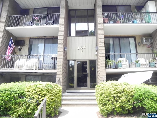 view of building exterior with entry steps and an AC wall unit