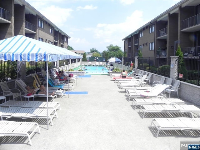 pool with a patio and fence