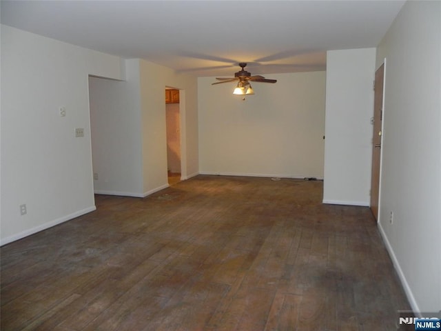 spare room with hardwood / wood-style floors, a ceiling fan, and baseboards