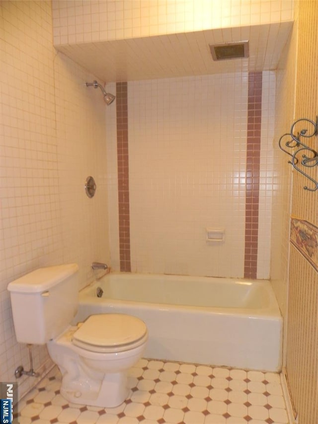 bathroom featuring washtub / shower combination, visible vents, and toilet