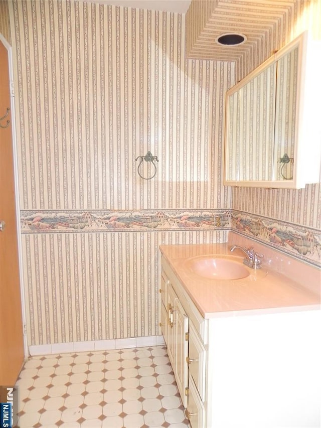 bathroom with wallpapered walls, vanity, and tile patterned floors