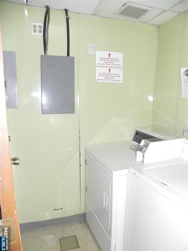 shared laundry area featuring light tile patterned floors, visible vents, washing machine and clothes dryer, and electric panel