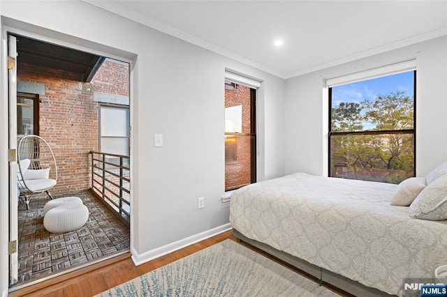 bedroom with brick wall, parquet floors, crown molding, and baseboards