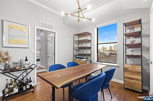 dining room featuring baseboards, visible vents, dark wood-style floors, ornamental molding, and a chandelier
