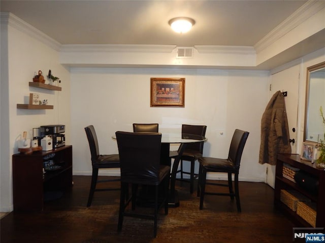 dining room with dark wood-type flooring, visible vents, and ornamental molding