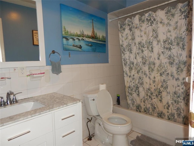 bathroom featuring shower / bath combination with curtain, vanity, toilet, and tile walls