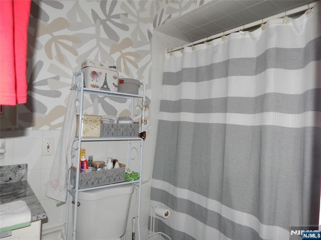 full bathroom with curtained shower, toilet, and vanity