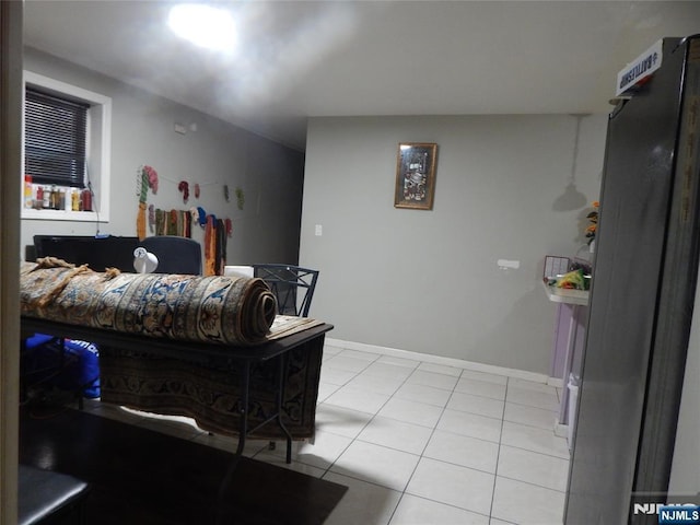 bedroom featuring light tile patterned floors and baseboards