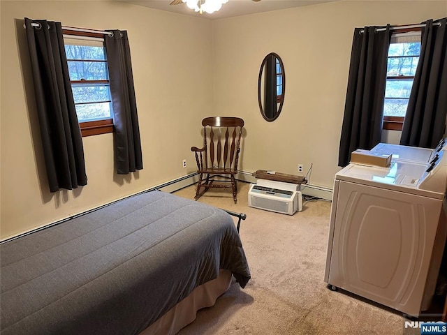 bedroom featuring multiple windows, washing machine and clothes dryer, and light colored carpet