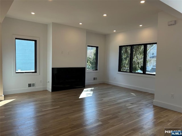 unfurnished living room featuring visible vents, recessed lighting, a fireplace, and baseboards