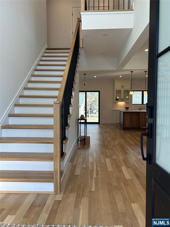 entryway with stairway, recessed lighting, light wood-type flooring, and baseboards