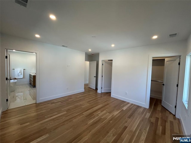 unfurnished bedroom with visible vents, recessed lighting, baseboards, and wood finished floors