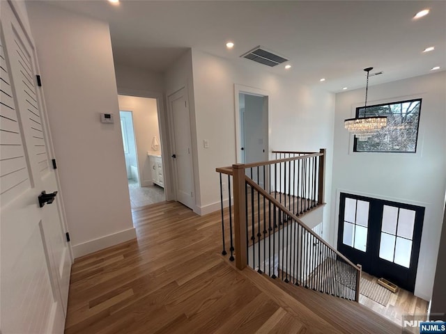 corridor with visible vents, an inviting chandelier, recessed lighting, an upstairs landing, and light wood-type flooring