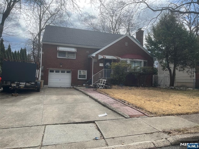 view of front facade featuring driveway, a shingled roof, a chimney, an attached garage, and brick siding