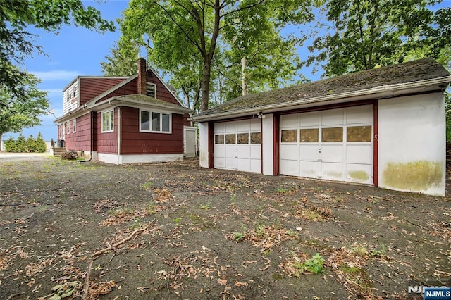 view of home's exterior featuring an outbuilding and a chimney