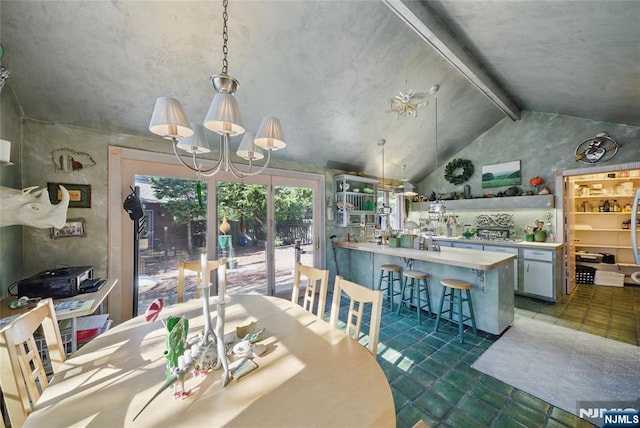 dining area featuring lofted ceiling with beams and a chandelier