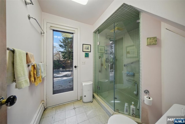 bathroom with a stall shower, toilet, and a baseboard radiator