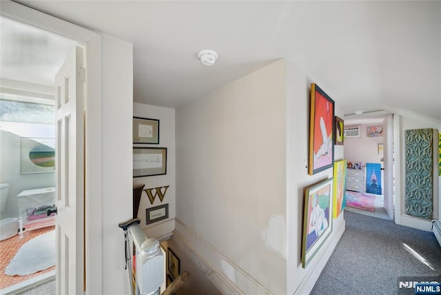 hallway featuring carpet floors and lofted ceiling