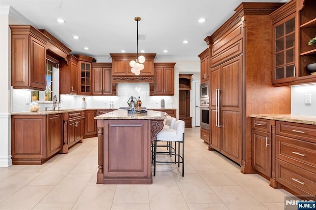 kitchen with a center island, brown cabinets, glass insert cabinets, a sink, and built in appliances