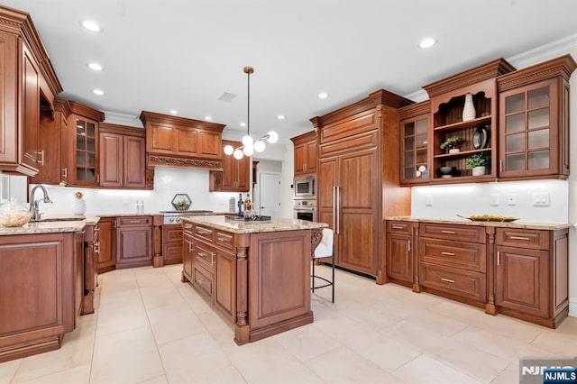 kitchen featuring a center island, brown cabinetry, a sink, and built in appliances