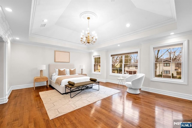 bedroom with baseboards, wood-type flooring, a raised ceiling, and a notable chandelier