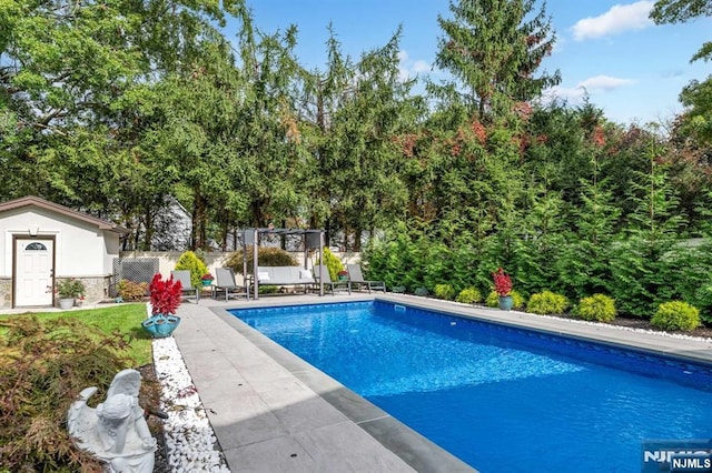 outdoor pool with a patio area and fence