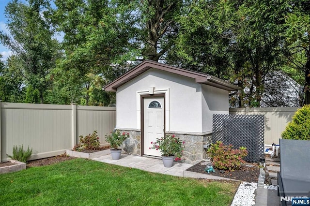 view of outdoor structure with a fenced backyard and an outdoor structure