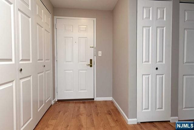 doorway to outside featuring light wood-type flooring and baseboards