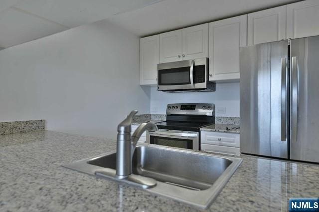 kitchen with white cabinets, stainless steel appliances, and a sink