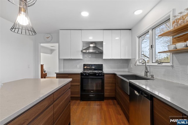 kitchen with white cabinets, black range with gas cooktop, stainless steel dishwasher, wall chimney range hood, and modern cabinets