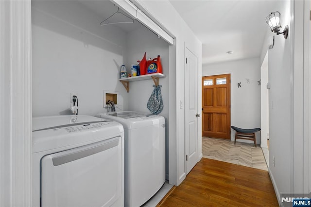 laundry room featuring laundry area, parquet flooring, and washing machine and dryer