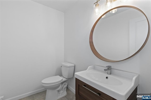 bathroom featuring tile patterned floors, baseboards, toilet, and vanity