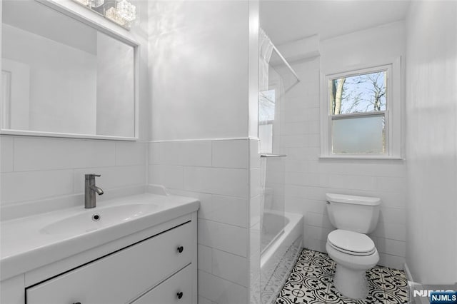 full bath with vanity, washtub / shower combination, tile walls, toilet, and tile patterned floors