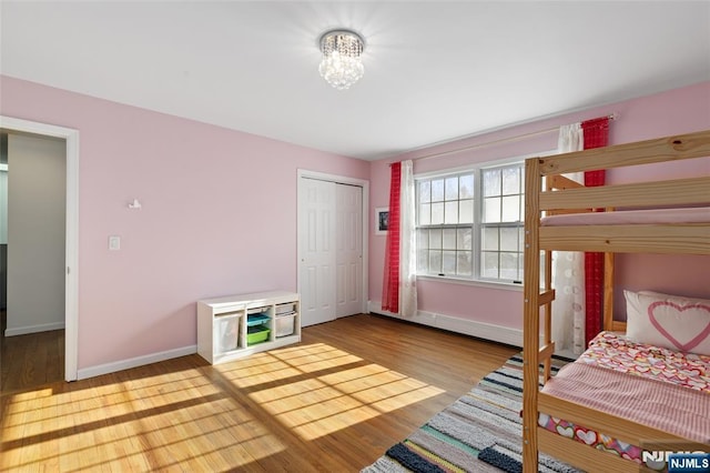 bedroom featuring a closet, baseboards, and wood finished floors