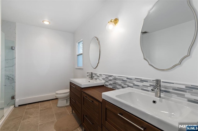 bathroom featuring decorative backsplash, a stall shower, baseboard heating, and a sink