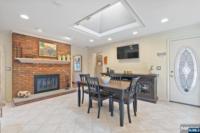 dining area featuring crown molding, light tile patterned floors, a fireplace, and recessed lighting