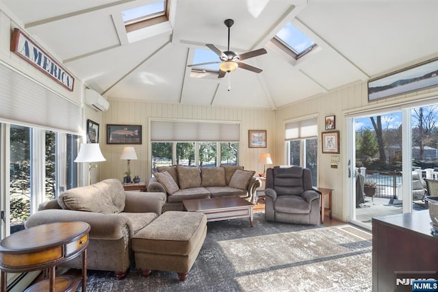 living room with a wealth of natural light, ceiling fan, a skylight, and a wall unit AC