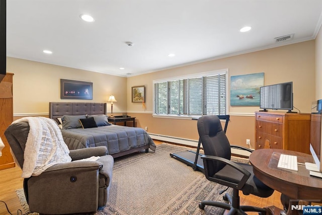 bedroom featuring visible vents, baseboard heating, wood finished floors, and crown molding