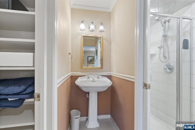 full bathroom featuring tile patterned flooring, a stall shower, and ornamental molding