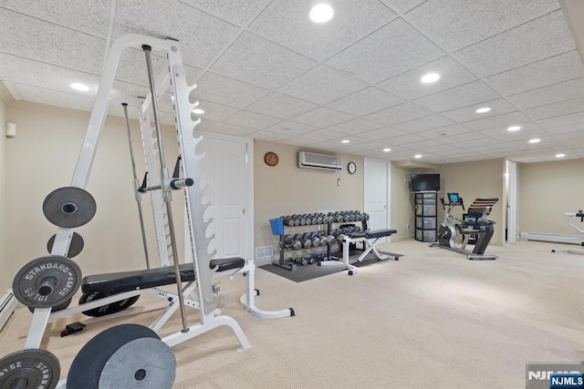 workout area featuring visible vents, a baseboard heating unit, baseboards, a wall mounted air conditioner, and recessed lighting