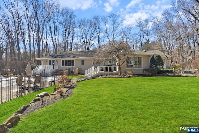 back of house featuring a lawn and fence