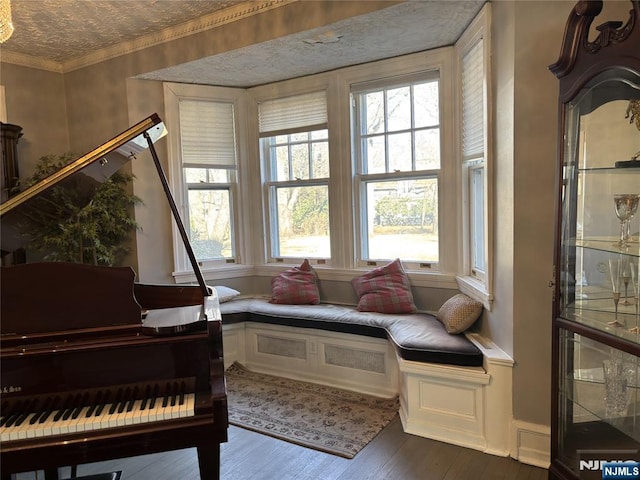 sitting room with dark wood-style floors, plenty of natural light, and ornamental molding