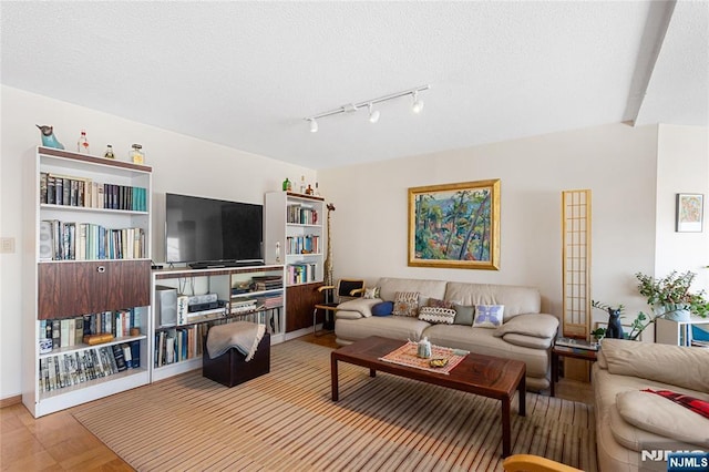 living area featuring a textured ceiling and baseboards