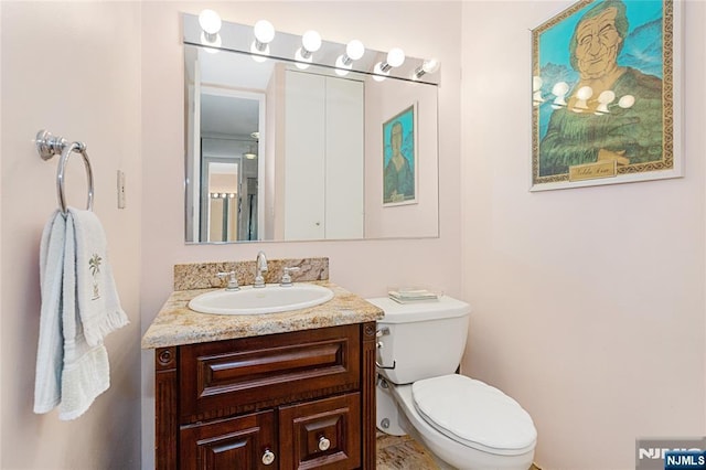 half bathroom with vanity and toilet