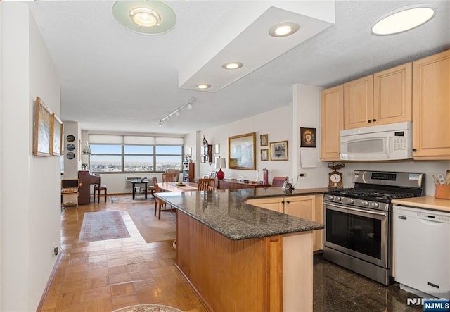 kitchen with recessed lighting, light brown cabinetry, open floor plan, white appliances, and a peninsula